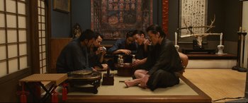 Movie still from “Why Don't You Play in Hell?” (2013), directed by Sion Sono – A group of men sitting on the floor drinking tea; Wide shot, High angle