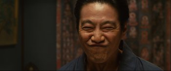 Movie still from “Why Don't You Play in Hell?” (2013), directed by Sion Sono – An asian man with his eyes closed and his mouth wide open; Close Up shot, Low angle
