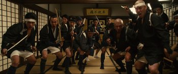 Movie still from “Why Don't You Play in Hell?” (2013), directed by Sion Sono – A group of men in traditional japanese garb holding swords; Wide shot, Low angle