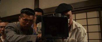 Movie still from “Why Don't You Play in Hell?” (2013), directed by Sion Sono – A group of men standing next to each other holding a camera; Close Up shot, Low angle