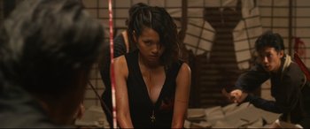 Movie still from “Why Don't You Play in Hell?” (2013), directed by Sion Sono – A woman with a cross on her chest and blood on her face; Medium shot, High angle