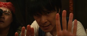Movie still from “Why Don't You Play in Hell?” (2013), directed by Sion Sono – A person with their hands up in the air; Extreme Close Up shot, Low angle