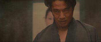Movie still from “Why Don't You Play in Hell?” (2013), directed by Sion Sono – A person wearing a black shirt; Close Up shot, Low angle