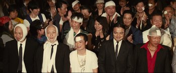 Movie still from “Why Don't You Play in Hell?” (2013), directed by Sion Sono – A group of people wearing white bandages on their heads; Medium shot, High angle