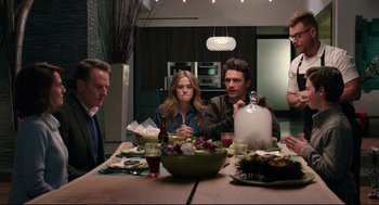 Movie still from “Why Him?” (2016), directed by John Hamburg – A group of people sitting at a table with food; Medium shot, Over the shoulder angle