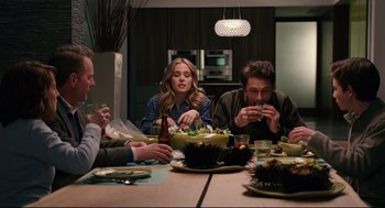 Movie still from “Why Him?” (2016), directed by John Hamburg – A group of people sitting around a table eating food; Medium shot, High angle