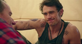 Movie still from “Why Him?” (2016), directed by John Hamburg – A person with tattoos on their arms; Close Up shot, Over the shoulder angle