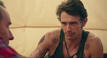Movie still from “Why Him?” (2016), directed by John Hamburg – A person with a tattoo on their arm; Close Up shot, Over the shoulder angle