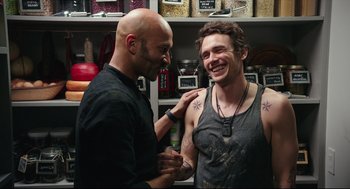 Movie still from “Why Him?” (2016), directed by John Hamburg – A man with a shaved head and a man with a tattoo on his chest; Medium shot, Over the shoulder angle