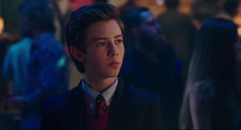 Movie still from “Why Him?” (2016), directed by John Hamburg – A young man in a suit and tie looking to his left; Close Up shot, Over the shoulder angle