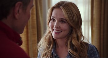 Movie still from “Why Him?” (2016), directed by John Hamburg – A woman smiles at the camera while talking to a man; Close Up shot, Over the shoulder angle