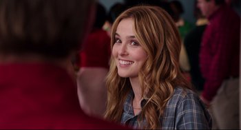 Movie still from “Why Him?” (2016), directed by John Hamburg – A beautiful young lady smiling for the camera; Close Up shot, Over the shoulder angle
