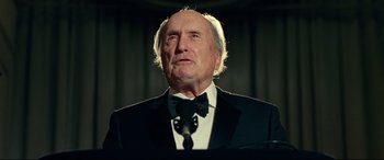 Movie still from “Widows” (2018), directed by Steve McQueen – An older man in a suit and bow tie; Close Up shot, Low angle