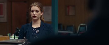 Movie still from “Widows” (2018), directed by Steve McQueen – A young woman in a black jacket is looking at the camera; Close Up shot, Over the shoulder angle