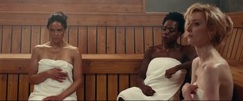 Movie still from “Widows” (2018), directed by Steve McQueen – Two women sitting on a bench in a sauna; Medium shot, High angle