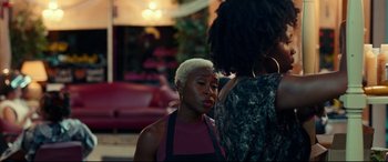 Movie still from “Widows” (2018), directed by Steve McQueen – A woman with short blonde hair is talking to another woman; Medium shot, Over the shoulder angle