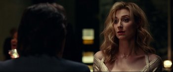 Movie still from “Widows” (2018), directed by Steve McQueen – A woman in a white dress is sitting next to a man in a black suit; Close Up shot, Over the shoulder angle