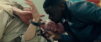 Movie still from “Widows” (2018), directed by Steve McQueen – Two men one of whom is holding a pair of shears; Close Up shot, Overhead angle