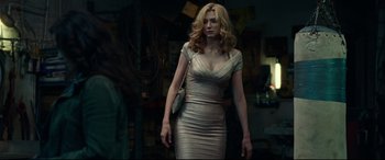 Movie still from “Widows” (2018), directed by Steve McQueen – A woman in a silver dress holding a purse; Medium shot, Over the shoulder angle