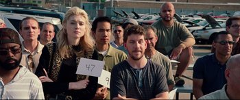 Movie still from “Widows” (2018), directed by Steve McQueen – A group of men and women standing in front of each other; Medium shot, Over the shoulder angle