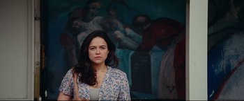 Movie still from “Widows” (2018), directed by Steve McQueen – A woman standing in front of a painting; Medium shot, Low angle