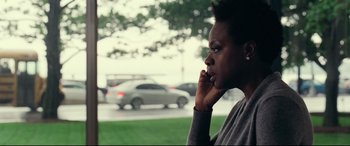 Movie still from “Widows” (2018), directed by Steve McQueen – A black woman talking on a cell phone outside; Close Up shot, Over the shoulder angle