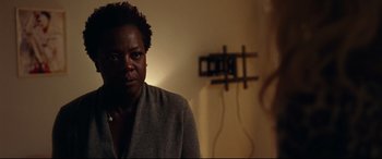 Movie still from “Widows” (2018), directed by Steve McQueen – A woman is standing in front of a wall; Close Up shot, Over the shoulder angle