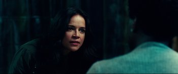 Movie still from “Widows” (2018), directed by Steve McQueen – A woman with long black hair is sitting in a dark room; Close Up shot, Over the shoulder angle