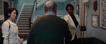 Movie still from “Widows” (2018), directed by Steve McQueen – An older man and a younger woman in front of a staircase; Medium shot, Over the shoulder angle