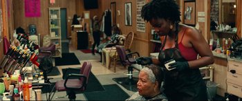 Movie still from “Widows” (2018), directed by Steve McQueen – A woman getting her hair cut at a hair salon; Medium shot, Over the shoulder angle