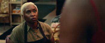 Movie still from “Widows” (2018), directed by Steve McQueen – A person sitting at a table looking at the camera; Close Up shot, Over the shoulder angle