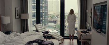 Movie still from “Widows” (2018), directed by Steve McQueen – A woman in a robe looking out of a window; Wide shot, Over the shoulder angle