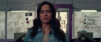 Movie still from “Widows” (2018), directed by Steve McQueen – A woman with long black hair wearing a jean jacket; Close Up shot, Over the shoulder angle