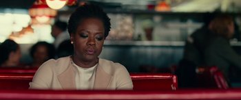 Movie still from “Widows” (2018), directed by Steve McQueen – A woman sitting at a table in front of a laptop computer; Close Up shot, Over the shoulder angle
