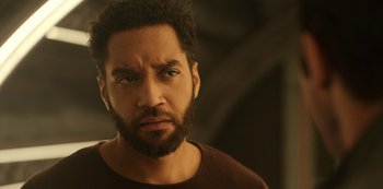 Movie still from “Another Life” (2019), created by Aaron Martin – A person with a beard looking at the camera; Close Up shot, Over the shoulder angle