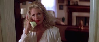 Movie still from “Wild at Heart” (1990), directed by David Lynch – A woman talking on a phone while wearing a white shirt; Close Up shot, Low angle