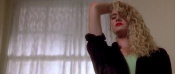 Movie still from “Wild at Heart” (1990), directed by David Lynch – A woman with red lipstick is standing in front of a window; Close Up shot, Low angle