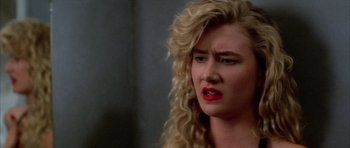 Movie still from “Wild at Heart” (1990), directed by David Lynch – A woman with blonde curly hair and red lipstick; Close Up shot, Over the shoulder angle