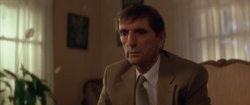 Movie still from “Wild at Heart” (1990), directed by David Lynch – A person wearing a suit and tie; Close Up shot, Low angle