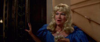 Movie still from “Wild at Heart” (1990), directed by David Lynch – A woman in a blue dress is holding a glass; Close Up shot, Over the shoulder angle