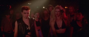 Movie still from “Wild at Heart” (1990), directed by David Lynch – A group of people standing in front of a stage; Medium shot, Low angle