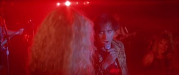 Movie still from “Wild at Heart” (1990), directed by David Lynch – A man and a woman are singing in front of a red light; Close Up shot, Over the shoulder angle
