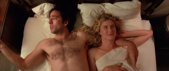 Movie still from “Wild at Heart” (1990), directed by David Lynch – A man and a woman laying in bed together; Close Up shot, Overhead angle
