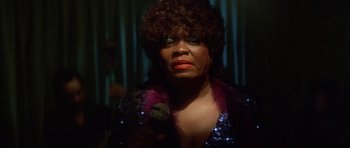 Movie still from “Wild at Heart” (1990), directed by David Lynch – A person holding a microphone; Close Up shot, High angle