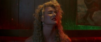 Movie still from “Wild at Heart” (1990), directed by David Lynch – A woman with blonde curly hair and red lipstick; Close Up shot, Low angle