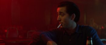 Movie still from “Wild at Heart” (1990), directed by David Lynch – A man is smoking a cigarette in a dark room; Close Up shot, Low angle