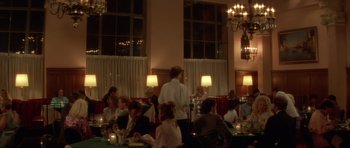 Movie still from “Wild at Heart” (1990), directed by David Lynch – A group of people sitting at a table in a restaurant; Wide shot, Over the shoulder angle