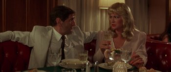 Movie still from “Wild at Heart” (1990), directed by David Lynch – A man and a woman sitting at a dinner table; Medium shot, Over the shoulder angle