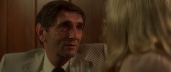 Movie still from “Wild at Heart” (1990), directed by David Lynch – A person wearing a suit and tie; Close Up shot, Over the shoulder angle