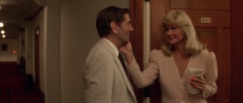 Movie still from “Wild at Heart” (1990), directed by David Lynch – A man and a woman standing next to each other in a room; Medium shot, Over the shoulder angle